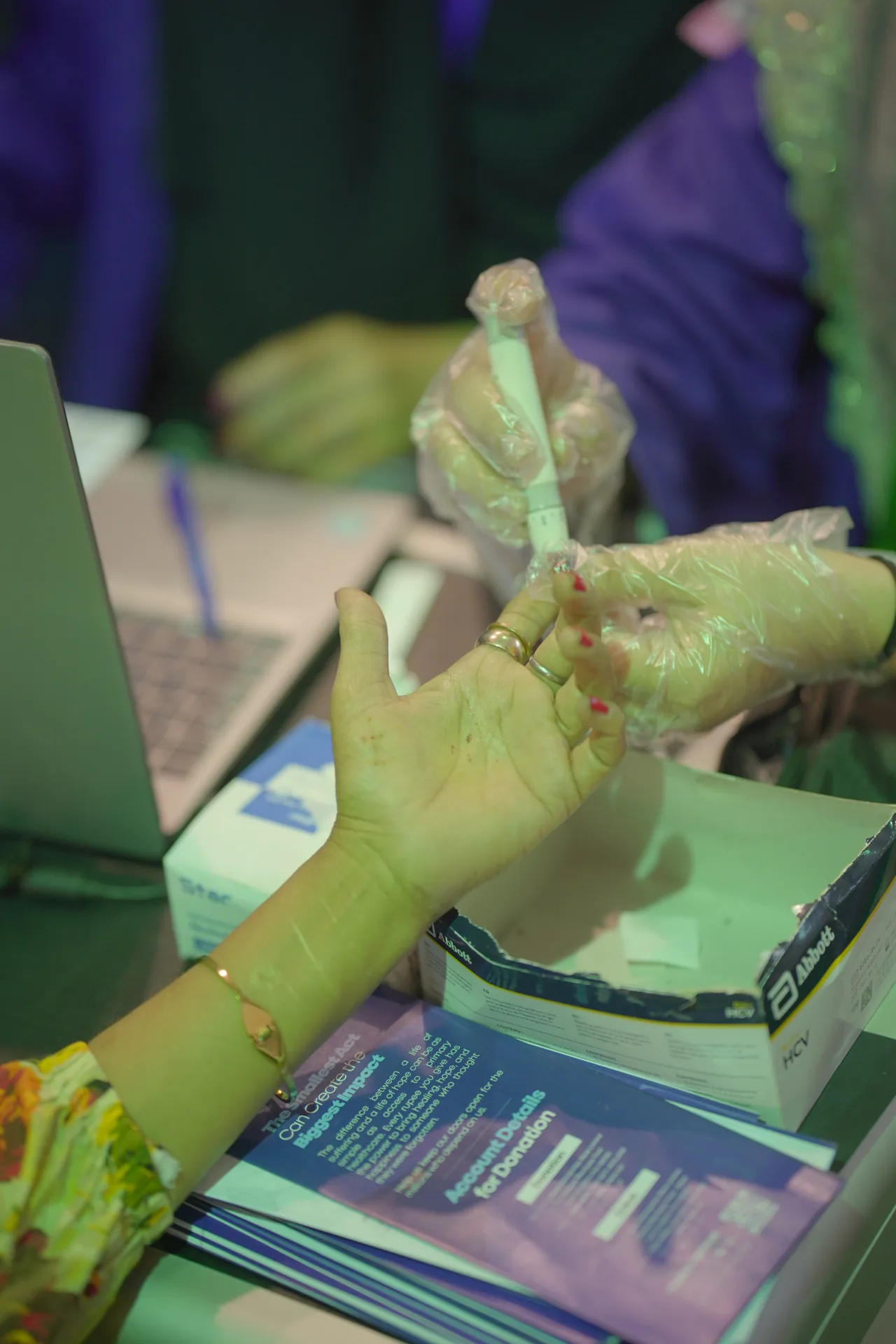 A patient's finger being pricked for a free blood test