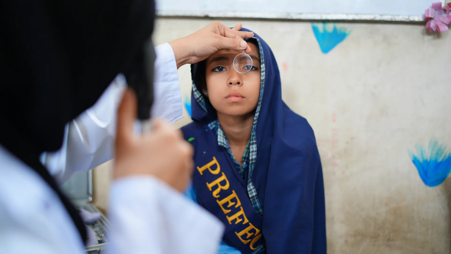 A schoolgirl having her eyes examined at a ZMT school screening