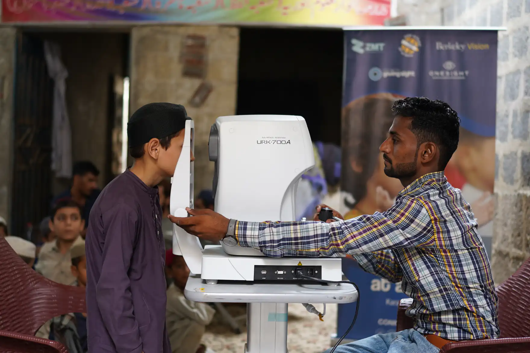 A boy having his eyes scanned during a ZMT school screening programme