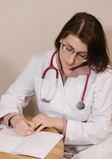 Doctor writing a prescription at her desk, care that clinic sponsorship funds