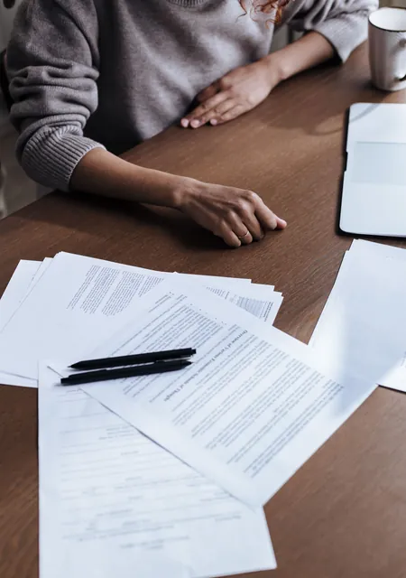 Paperwork spread on a desk under review, the due diligence a CSR team does