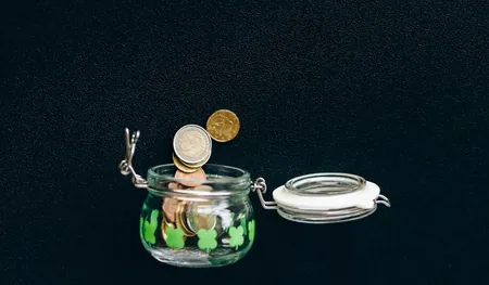 Coins dropping into a glass jar, a picture of small, regular sadaqah