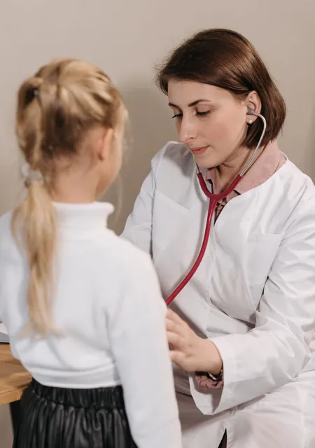 Doctor checking a child with a stethoscope, the kind of consultation zakat for medical treatment covers
