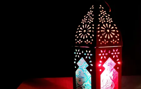 Lit Ramadan lantern in a dark room, the month many people donate zakat
