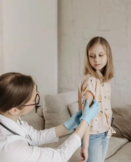 Doctor giving a child a vaccine, care whose benefit lasts for years
