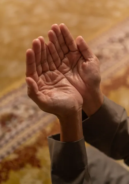 Hands raised in dua, as families pray when giving sadqa for a sick person