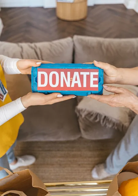 Hands passing a box marked Donate, a simple picture of giving sadqa online