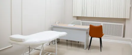 Empty examination room with a couch, desk and chairs, the space a sponsor keeps open