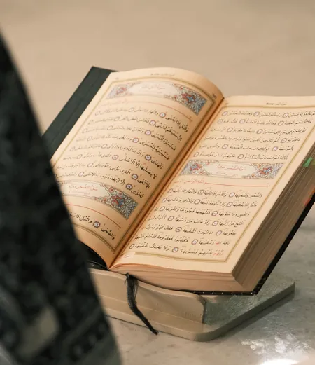 Open Quran on a wooden stand; the Quran names who is zakat eligible
